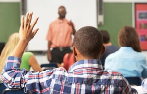 Child with his hand up in a classroom